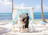 Boda de escapada en una playa de Punta Cana con arco blanco y azul
